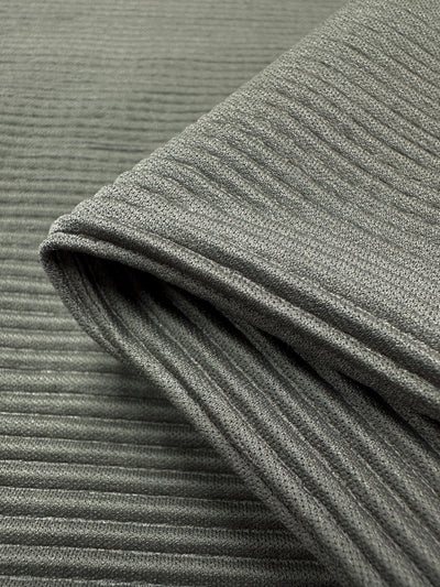 Close-up of Pleat - Pewter - 140cm fabric by Super Cheap Fabrics. This gray ribbed polyester material features a lightweight, textured surface with parallel ridges creating vertical lines.