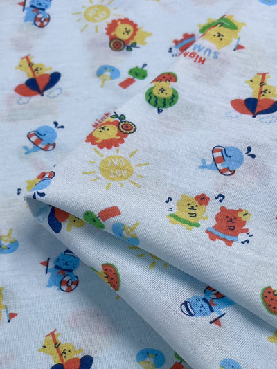 Take a look at the Printed Jersey - Summer Times by Super Cheap Fabrics. This light blue stretch fabric features a playful animal pattern with lions, bears, and whales enjoying summer activities such as swimming and playing instruments. The addition of bright red, yellow, and blue hues brings a cheerful vibe to this vibrant 180cm jersey.