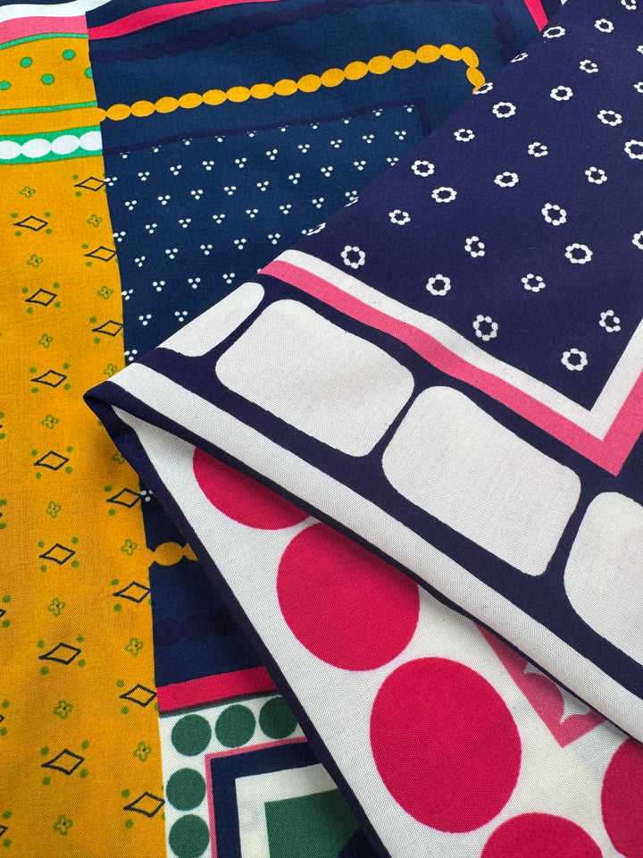 Designer Rayon - Stile by Super Cheap Fabrics features vibrant geometric shapes, polka dots, and small motifs in navy blue, white, yellow, green, and pink on overlapping patterned rayon fabric. Width: 145cm.