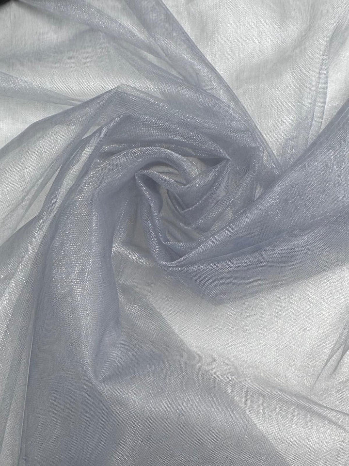 Organza - Illusion Blue by Super Cheap Fabrics is a sheer, lightweight fabric in a subtle blue shade. Its smooth, slightly shiny surface features gentle folds and delicate translucence. The material is 150cm wide.