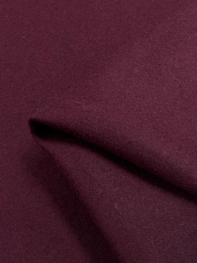 Close-up of the Merino Wool - Chocolate Truffle from Super Cheap Fabrics, highlighting its heavy weight and smooth texture. The deep, rich burgundy fabric shows soft folds and subtle shading variations due to lighting.