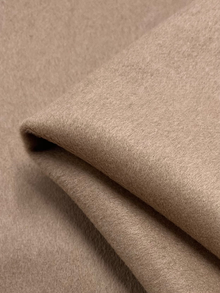 A close-up of Super Cheap Fabrics' Wool Cashmere - Brush, 150cm wide, reveals its warm, smooth texture and soft curves—ideal for crafting cozy outer coats.