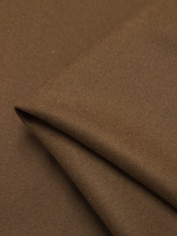 A close-up shot of neatly folded brown fabric. The surface appears to be smooth and soft, suggesting it may be made of **Melton Wool - Caramel Cafe - 150cm** by **Super Cheap Fabrics**. The fabric's texture and rich caramel cafe color are clearly visible, creating a warm and cozy appearance.