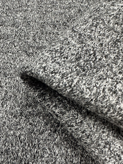 Close-up image of a folded gray knitted fabric, Boiled Wool - Grey Marle - 140cm by Super Cheap Fabrics. The texture and weave pattern are clearly visible, showcasing a soft and cozy appearance. The heavy-weight wool appears thick and suitable for autumn/winter clothing or blankets.