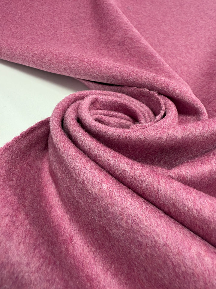 A close-up of Super Cheap Fabrics' Wool Cashmere - Wild Rose (150cm), featuring soft pink premium fabric in a swirl pattern, highlighting its smooth texture and gentle folds.