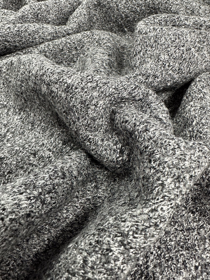 A close-up of Boiled Wool - Grey Marle - 140cm by Super Cheap Fabrics, likely heavy-weight wool. The image highlights the intricate and tightly woven fibers, emphasizing the cozy and soft appearance ideal for Autumn/Winter clothing. The fabric appears to be folded or draped loosely.