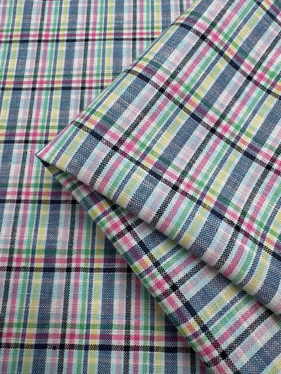 Two pieces of Super Cheap Fabrics' Linen Blend - Tartan Prism (140cm) in a multicolored plaid pattern—blue, pink, yellow, green, and white—are displayed with one piece folded atop the other.