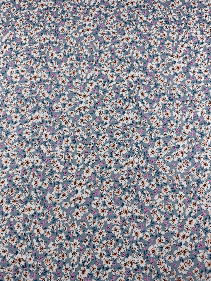 Super Cheap Fabrics' Cotton Sateen - Bluebell Meadows (150cm) features soft fabric with dense white, blue, and brown flowers plus green leaves on muted blue—perfect for creative projects.