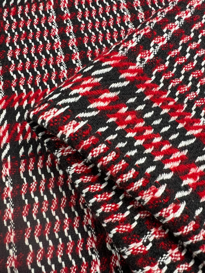 Close-up of Designer Wool - RWB - 150cm by Super Cheap Fabrics featuring a vibrant houndstooth pattern. The heavy weight fabric combines red, white, and black threads in an intricate, textured design, creating a bold, visually striking appearance. Ideal for skirts, jackets, and coats, the wool polyester blend appears folded in the image.