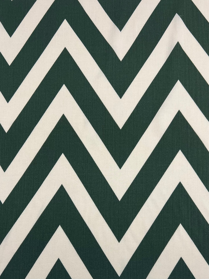 A lightweight fabric with a bold chevron pattern featuring alternating dark green and white stripes. The Super Cheap Fabrics Bamboo Rayon - Zag XL - 150cm material forms sharp, zigzag lines across the surface, perfect for versatile uses.