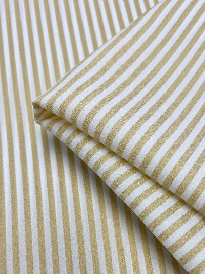 A close-up of Super Cheap Fabrics’ Striped Crepe - Raffia, 150cm wide, featuring beige and white vertical stripes and a smooth crepe texture—perfect for high fashion projects.