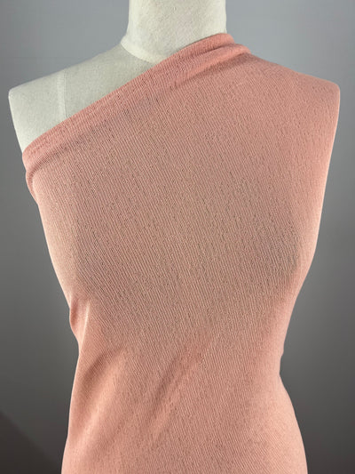 A mannequin wearing a sleeveless, one-shoulder pink top made of Lightweight Slub Jersey - Blossom - 150cm by Super Cheap Fabrics is shown against a neutral background. The fabric appears to be soft and has a generous stretch.