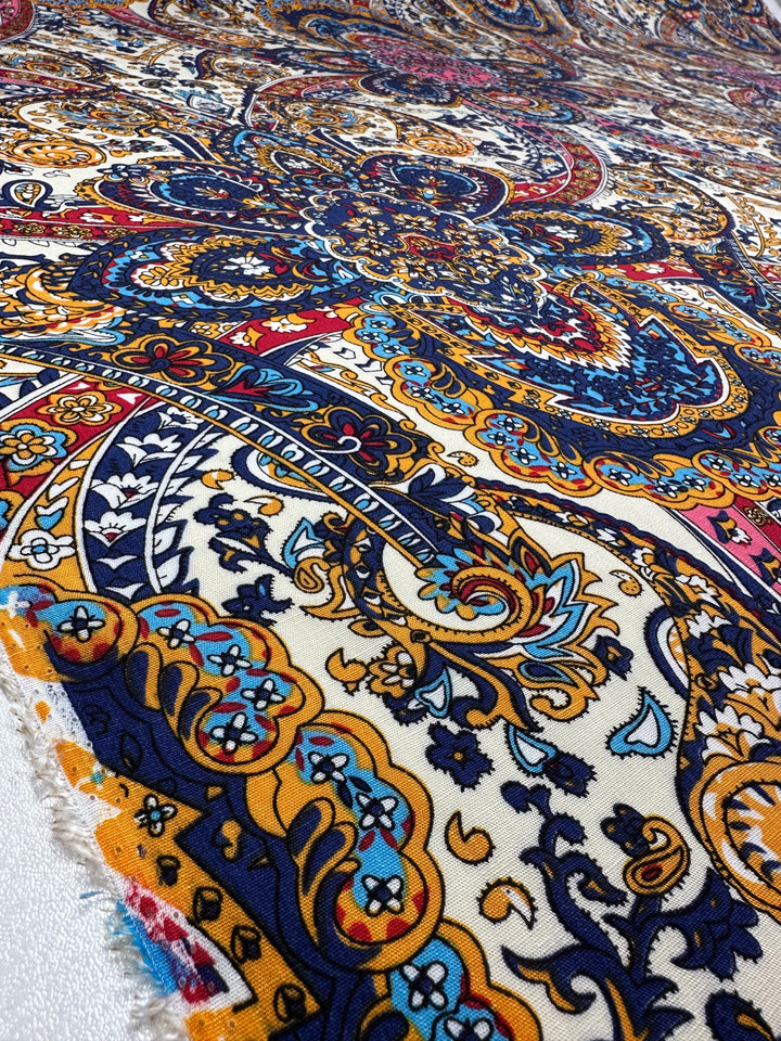 Super Cheap Fabrics' Bamboo Rayon - Moroccan (150cm): Lightweight, multi-use fabric with intricate blue, yellow, red, and white swirling floral and paisley patterns; close-up reveals its rich detail and soft texture.