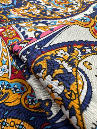 Close-up of Super Cheap Fabrics' Bamboo Rayon - Moroccan - 150cm, a lightweight fabric with intricate blue, yellow, red, and white paisley and floral designs—perfect for versatile projects.