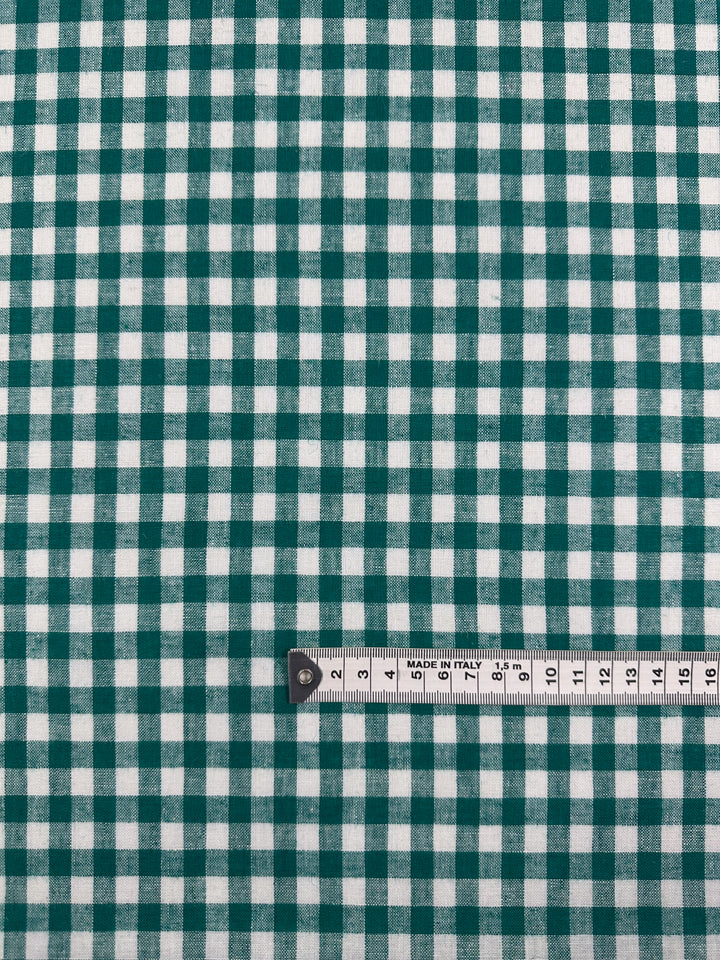 A white measuring tape (0–17 cm) rests on Super Cheap Fabrics' Linen Blend - Verdant Gingham (145cm), showing its lightweight, green-and-white checkered pattern with repeating squares.