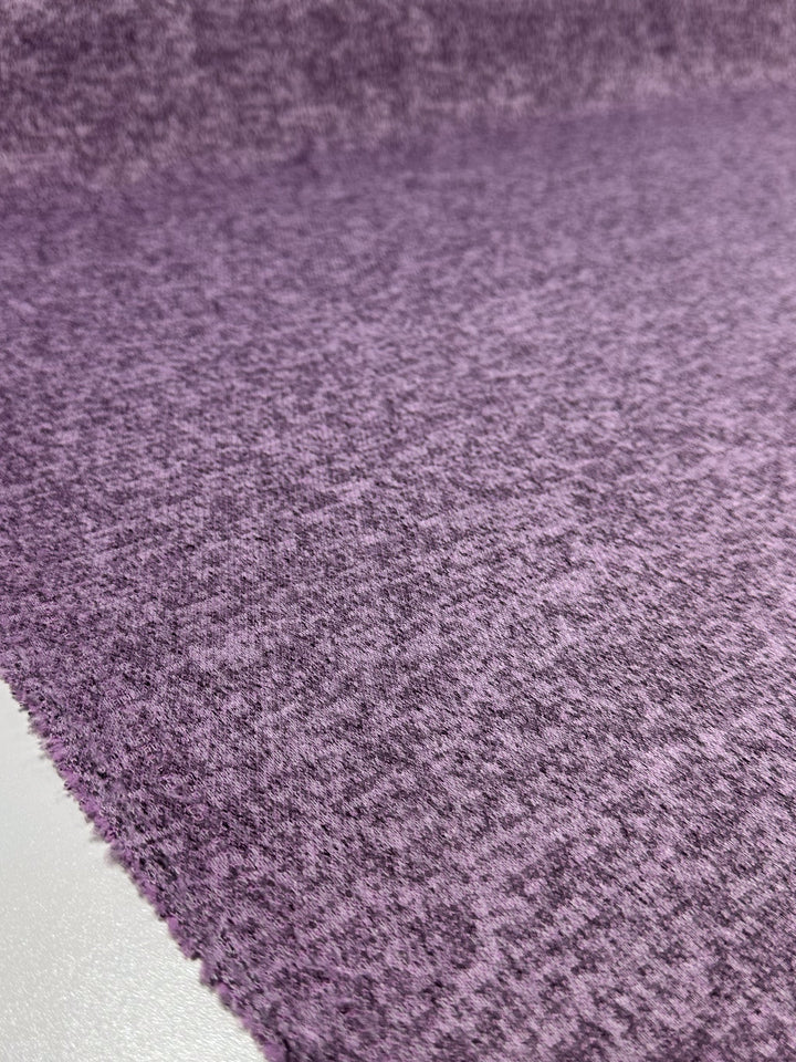 A close-up of Super Cheap Fabrics’ Textured Knit - Orchid Marle (150cm) shows its fine, medium-weight threads and mottled purple tones—ideal for anyone who loves textured knit fabrics.