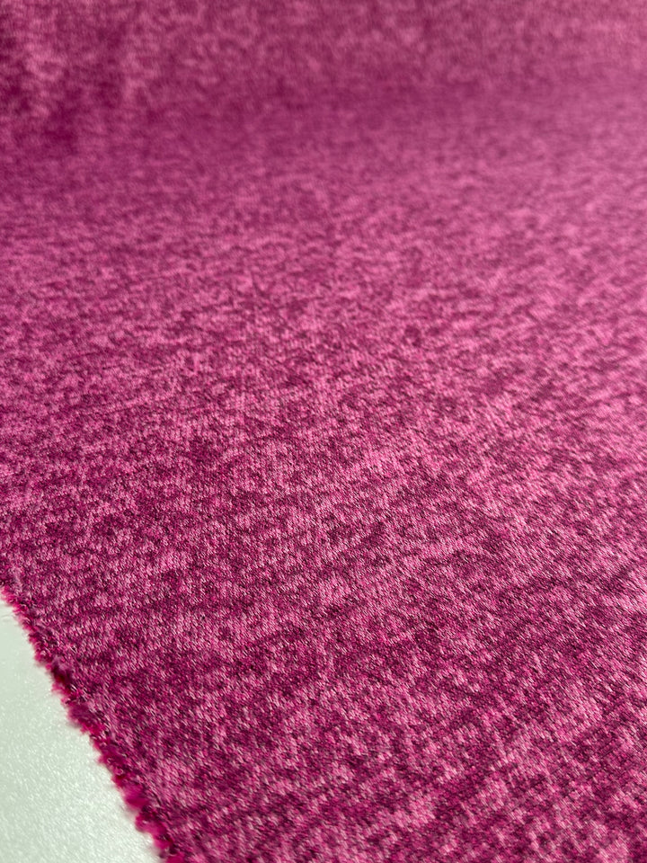 A close-up of Super Cheap Fabrics' Textured Knit - Rose Violet - 150cm shows the soft, medium weight fabric laid flat, highlighting its subtle color variations and characteristic textured weave detail.