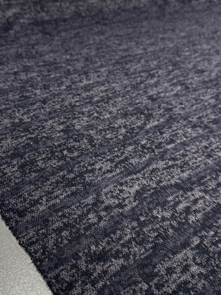 Close-up of Super Cheap Fabrics’ Textured Knit - Ink Marle - 150cm: a dark gray, heathered fabric with fine color variations and a soft, slightly fuzzy surface—ideal for lovers of unique designs and textured knits.