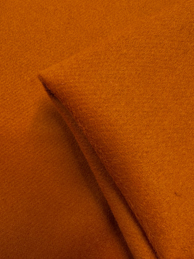 Close-up of Wool Cashmere - Hawaiian Sunset - 150cm by Super Cheap Fabrics, highlighting its luxurious softness, heavy weight, and warm, rich orange hue.