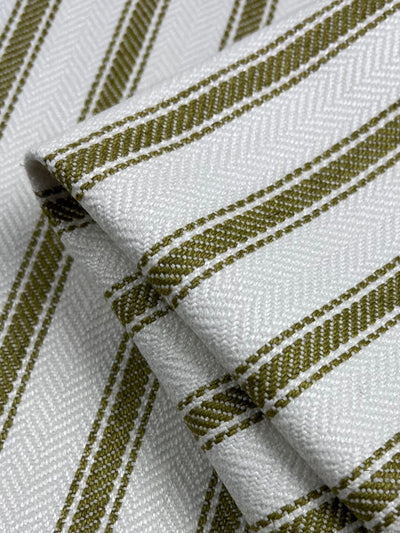 Close-up of neatly folded *Upholstery Herringbone - Willow - 145cm* from *Super Cheap Fabrics* with textured, diagonal lines and olive-green stripes running parallel across the surface. The durable fabric appears to be made of a sturdy material, showcasing a simple yet elegant design within an affordable range.