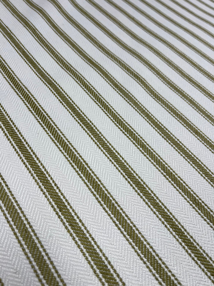 Close-up of Super Cheap Fabrics Upholstery Herringbone - Willow - 145cm with a pattern of alternating light green and white diagonal stripes. The white stripes have a subtle zigzag texture, while the green stripes are solid. The durable fabric appears to have a slightly textured weave, ideal for an affordable range of home decor projects.