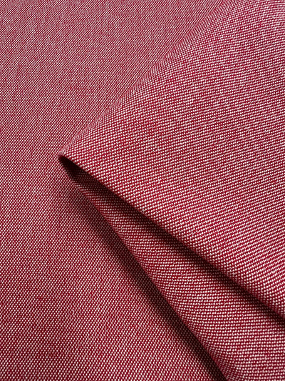 Close-up of a piece of Canvas - Rubocondo - 150cm from Super Cheap Fabrics, with a subtle textured pattern, showing folds and creases that emphasize its material quality. The dense weave, featuring small, evenly spaced threads, contributes to a slightly rough surface.