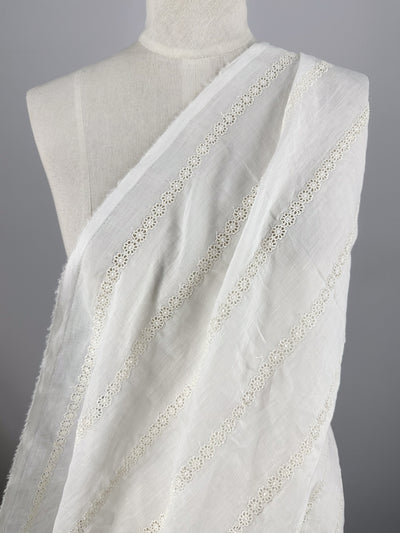 A white mannequin displays Super Cheap Fabrics' Pure Linen - Bridie (150cm), a lightweight, off-white sheer fabric with horizontal lace trim, set against a plain gray background.
