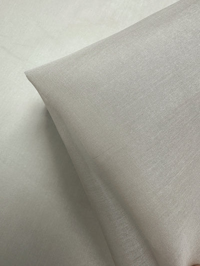 A close-up of Pure Silk Organza - White Onyx by Super Cheap Fabrics (135cm), with two ultra-light fabric layers—one folded—displaying a smooth, soft texture perfect for clothing.