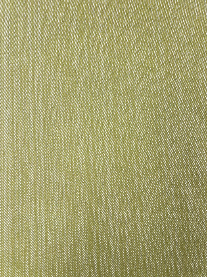 A close-up image of Super Cheap Fabrics' Upholstery Twill - Sweet Pea - 147cm, a green and yellow woven fabric with a vertical striped pattern. The texture of the upholstery twill threads is visible, creating a subtle, variegated look within the stripes. The colors are muted and blend smoothly, highlighting the durable fabric's craftsmanship.