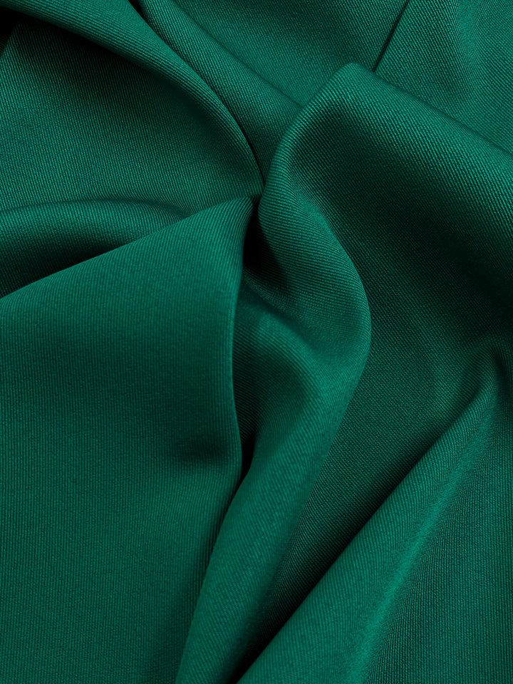 Close-up image of Twill Suiting - Ultramarine Green - 153cm, showcasing its smooth and slightly textured surface. The Super Cheap Fabrics material is gathered and folded, creating gentle curves that highlight its soft and flexible nature.