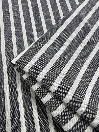 Close-up of Super Cheap Fabrics' Linen Cotton - Dark Gray Stripe - 145cm with a pattern of alternating horizontal grey and white stripes. The material, made from natural fibers, has a textured appearance and is known for being a breathable fabric.