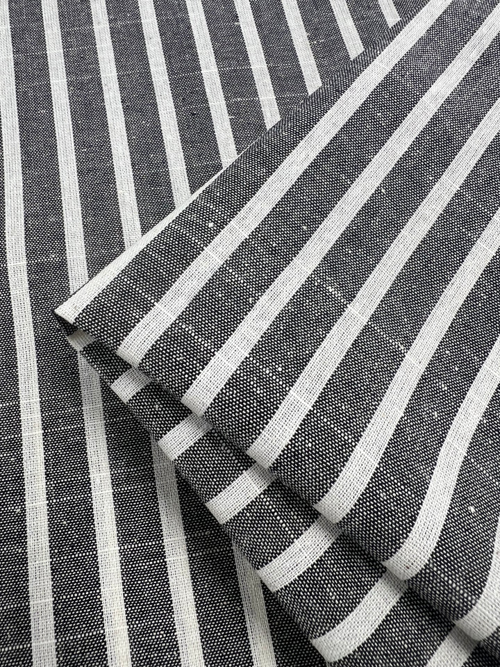 Close-up of Super Cheap Fabrics' Linen Cotton - Dark Gray Stripe - 145cm with a pattern of alternating horizontal grey and white stripes. The material, made from natural fibers, has a textured appearance and is known for being a breathable fabric.