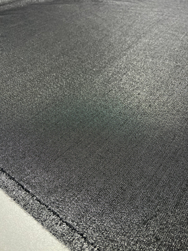 Close-up image of Super Cheap Fabrics' Wool Lamé - Metallic - 150cm fabric with a visible seam running horizontally across the bottom left corner. The lightweight fabric appears to have a slightly reflective and smooth surface.