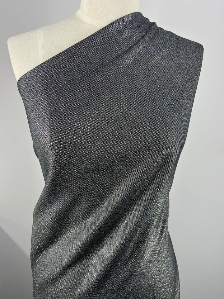 Close-up of a mannequin draped with Wool Lamé - Metallic - 150cm by Super Cheap Fabrics. The lightweight fabric appears to be wrapped diagonally, covering the torso, and has a metallic sheen under the light, highlighting its elegant and smooth texture.