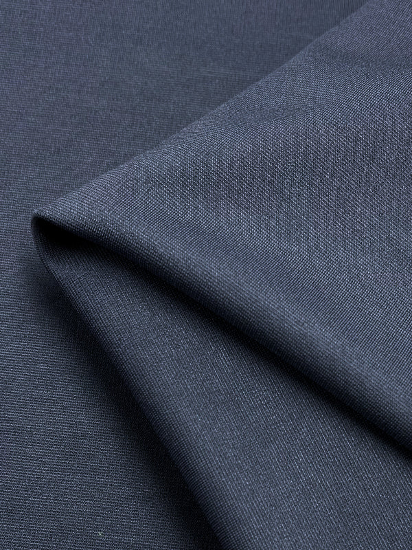 A close-up view of draped dark gray, wrinkle-resistant fabric with a smooth and slightly textured surface, showcasing the material's weave and soft folds. The product featured is Super Cheap Fabrics' Ponte - Grisaille - 155cm.