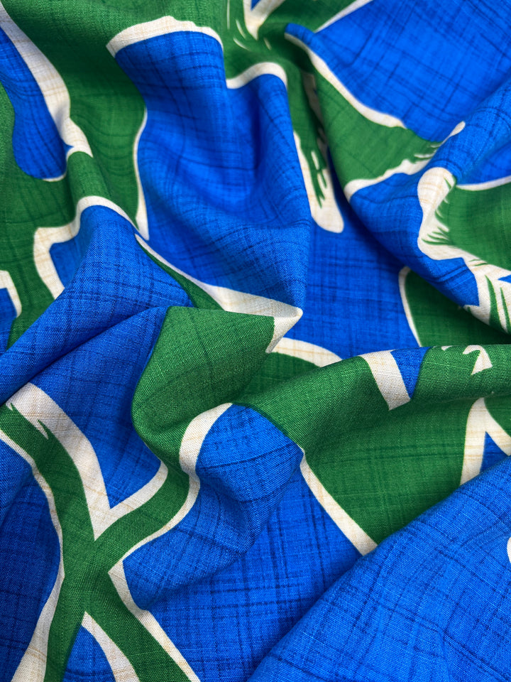 A blue and green Bamboo Rayon - Dance Indigo - 150cm from Super Cheap Fabrics with white designs, perfect for home decor.