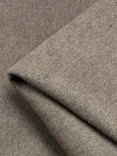 Close-up image of a folded piece of Wool Cashmere - Cobblestone - 150cm from Super Cheap Fabrics. The texture appears soft and slightly fuzzy, with fine details of the wool fibers visible. The fabric has a warm, neutral tone suitable for outer coats or upholstery.