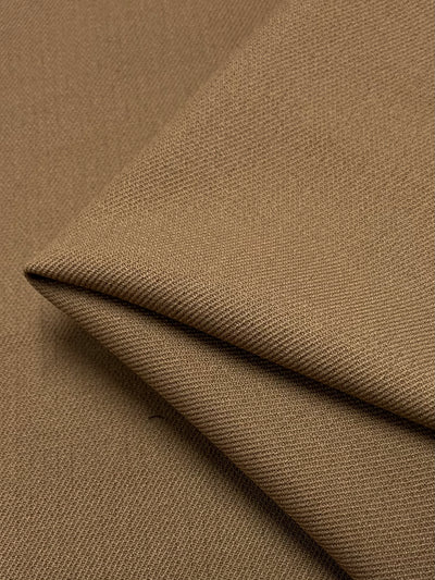 Close-up of a folded piece of Twill Suiting - Aztec - 138cm by Super Cheap Fabrics. The fabric appears smooth and soft, with the folds creating subtle shadows and highlights, typical of high-quality twill suiting.