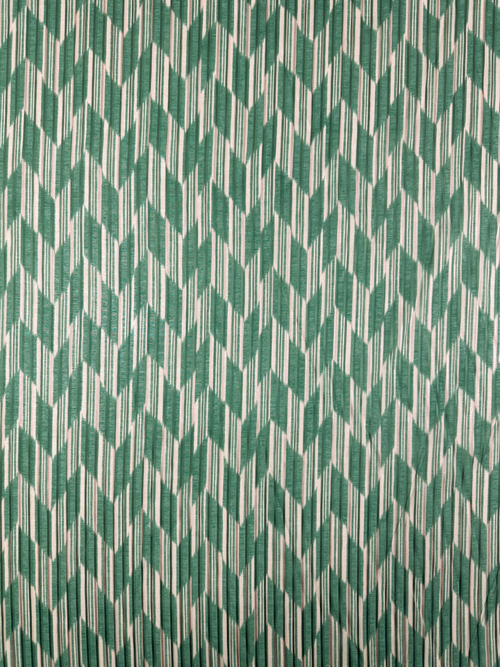 The Printed Silk - Escalate - 140cm from Super Cheap Fabrics features a green and white geometric pattern with interlocking angular shapes, giving it a textured, woven appearance. This repetitive design is ideal for dresses, offering both depth and movement along with lightweight comfort.