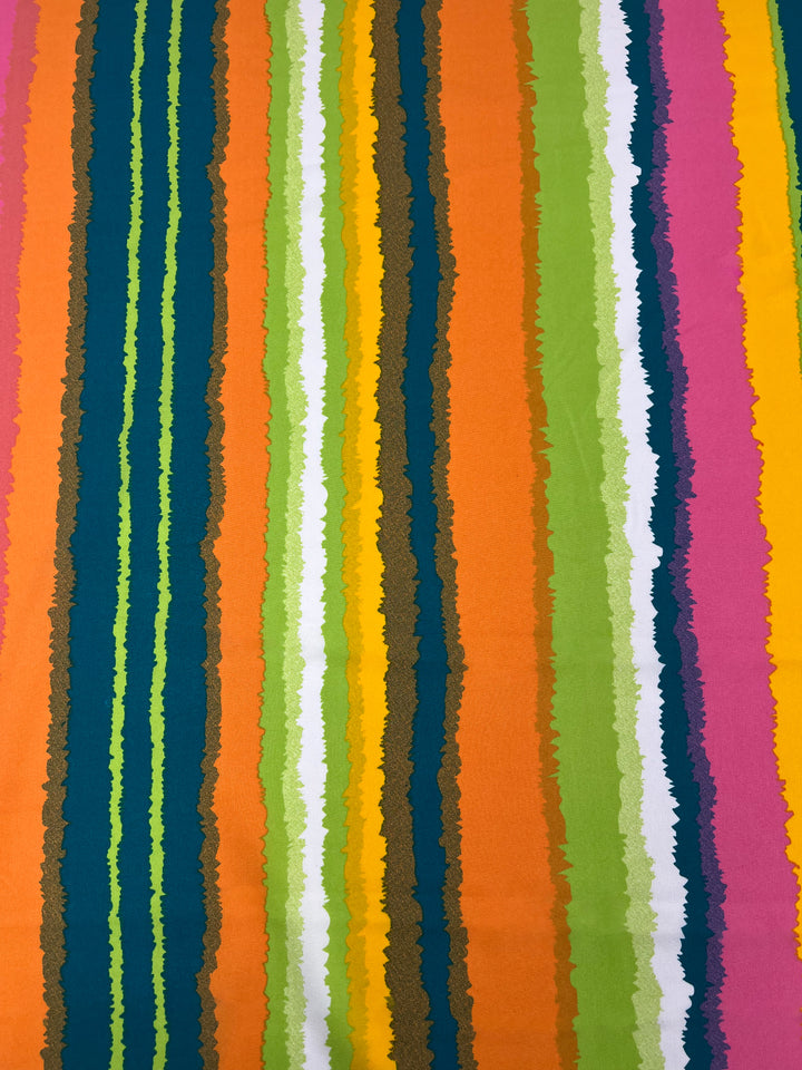 The Super Cheap Fabrics Deluxe Print - Lollipop - 155cm showcases vertical stripes with textured edges in vibrant shades of green, blue, yellow, orange, white, pink, and brown. The irregular, hand-painted appearance of this versatile fabric adds a designer touch to any project.