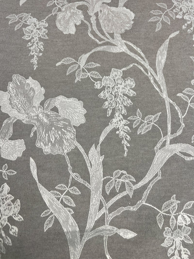 The Designer Damask - Saphire Dust by Super Cheap Fabrics showcases an ornate and delicate design, where white thread intricately embroiders a variety of botanical elements including intertwined leaves and flowers, all set against a luxurious gray fabric background.