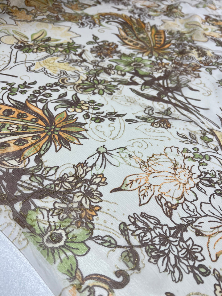 A close-up image of Pure Printed Silk - Jaipur by Super Cheap Fabrics reveals an intricate floral and butterfly pattern in multi-colored green, orange, and brown hues on a light background. The lightweight silk fabric has a slightly sheer quality, evoking a nature-inspired aesthetic.