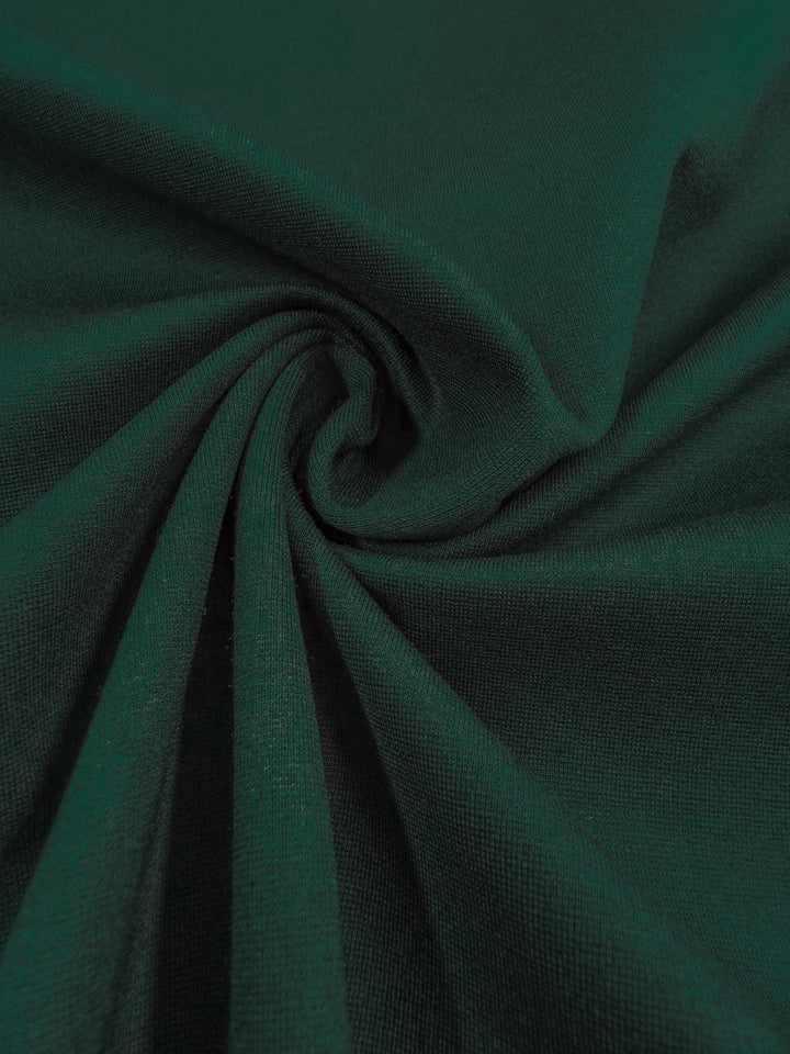Super Cheap Fabrics’ Milano Ponte - Pine Grove (160cm) is a dark green heavyweight ponte fabric with a soft texture, slight sheen, and 4-way stretch—perfect for structured skirts. Every thread and weave detail is beautifully visible.