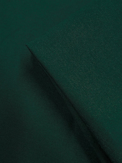 Close-up of Milano Ponte - Pine Grove by Super Cheap Fabrics (160cm): dark green heavyweight fabric with a smooth, slightly textured surface and folded corner showing its thickness—perfect for structured skirts.