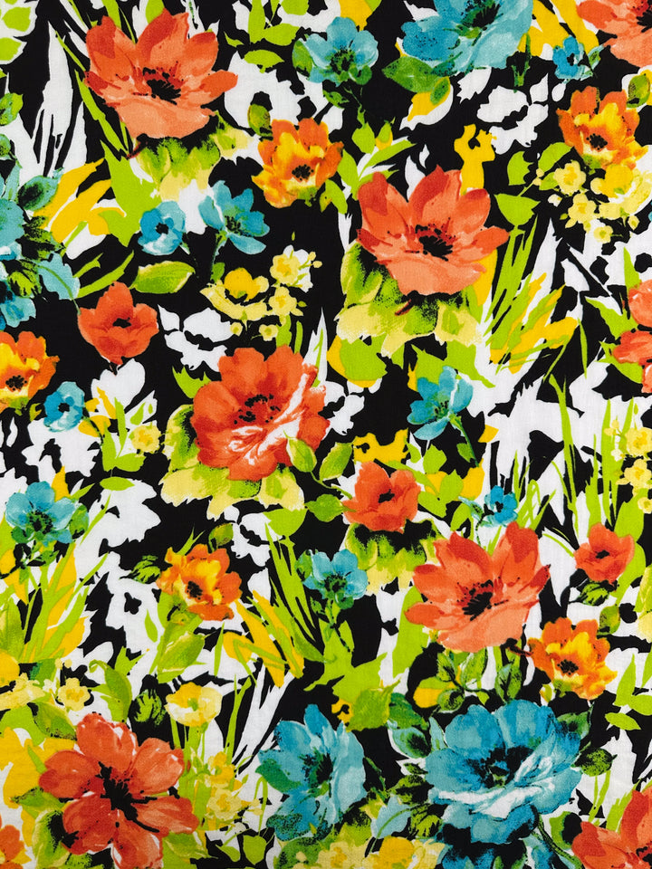 The Linen Blend - Black Forest fabric by Super Cheap Fabrics showcases a vibrant floral pattern with orange, blue, and yellow flowers and green leaves on a black background. This lively design is perfect for various home decor uses.