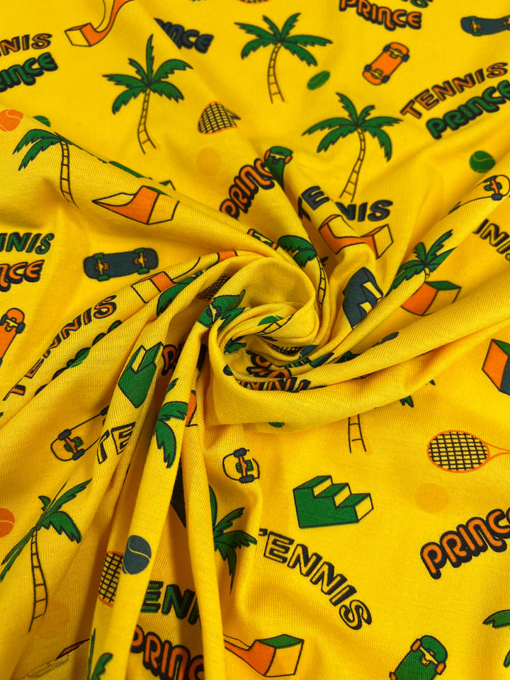 This lively fabric from Super Cheap Fabrics, known as the Printed Jersey - Tennis - 160cm, features a vibrant yellow background adorned with a swirled pattern of tennis rackets, palm trees, sandals, paddles, and multicolored "TENNIS" and "PRINCE" designs. It is crafted as a medium-weight jersey with two-way stretch for enhanced comfort and style.