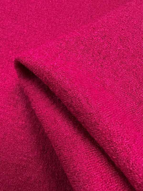 Close-up of Super Cheap Fabrics' Boiled Wool - Vivacious, 145cm. The vibrant pink wool-viscose blend exhibits a soft, textured surface with folds that accentuate its plush quality and thickness.