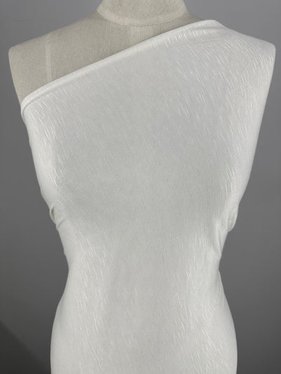 A white, one-shoulder dress displayed on a mannequin against a gray background. Made from durable Bamboo Jersey - Ivory - 155cm by Super Cheap Fabrics, the dress fits snugly on the figure, showcasing a minimalist and elegant design.
