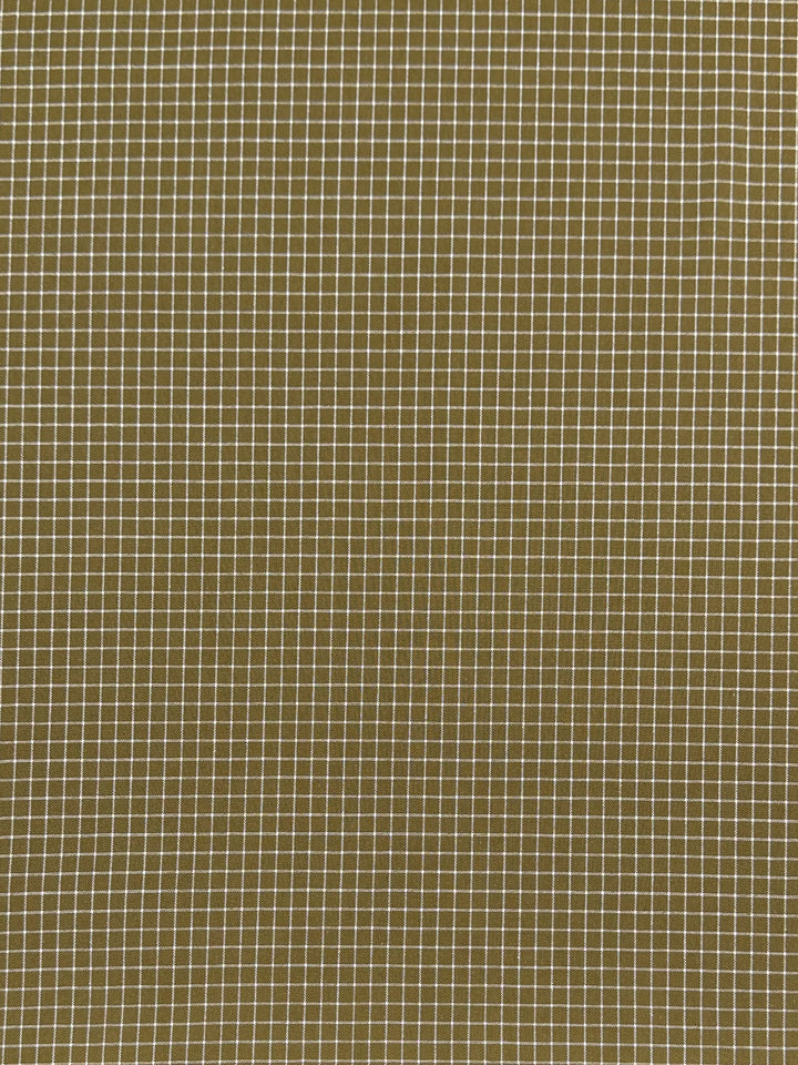 A pattern of perfectly aligned white grid lines forms small squares against an olive green background. This Linen Rayon Grid - Mustard - 145cm from Super Cheap Fabrics with its uniform grid creates a clean and structured geometric design, making it a perfect choice for home decor projects.