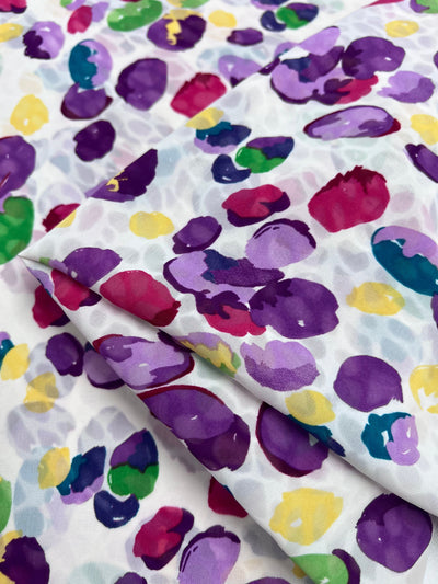 The Salt Shrunk Print - Pebbly by Super Cheap Fabrics features a vibrant polka dot pattern in purple, pink, green, yellow, and red on white from our elegant collection.